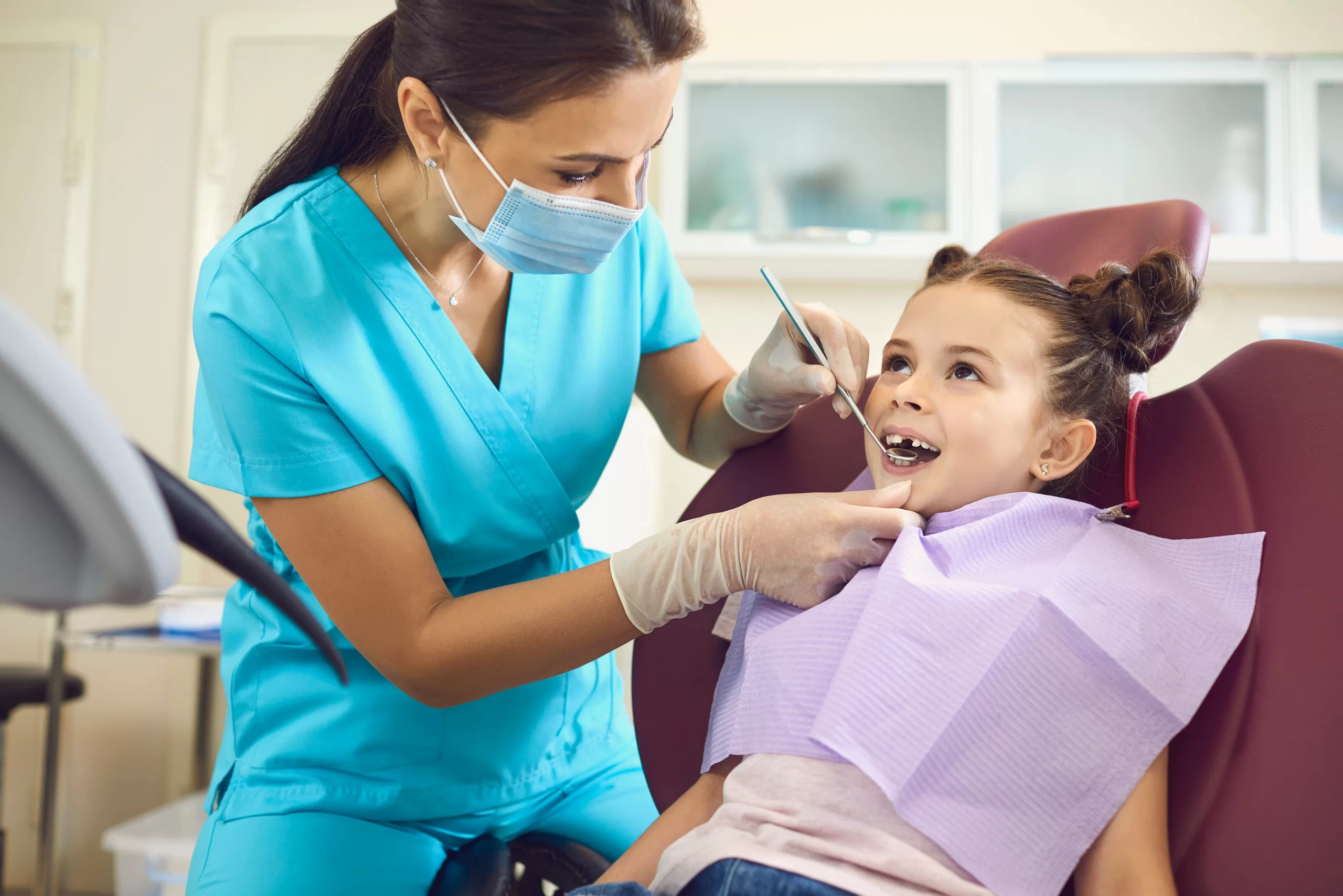 Dentist examining child's teeth at clinic. Space Maintainers For Kids