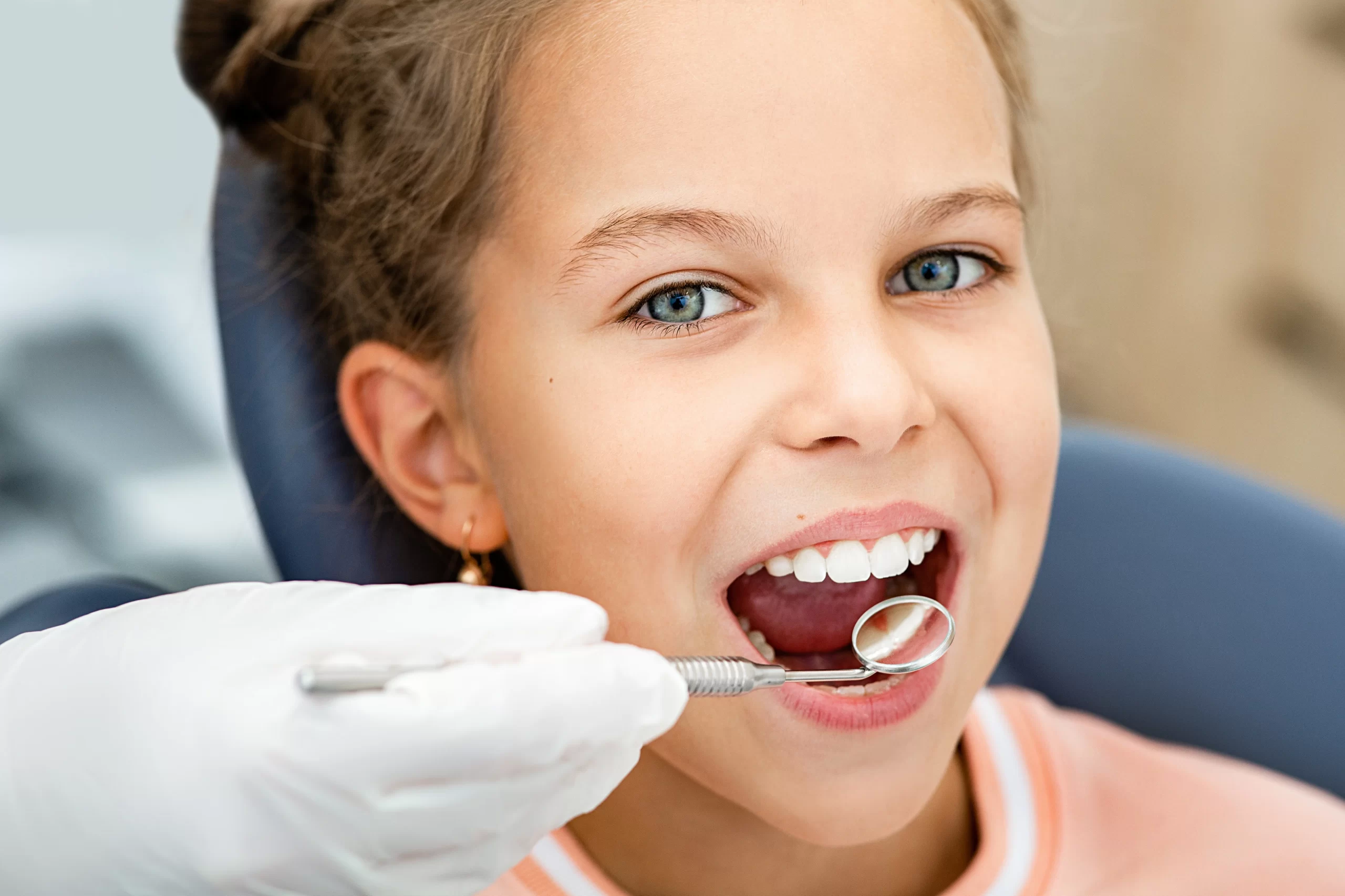 Child undergoing dental examination, smiling