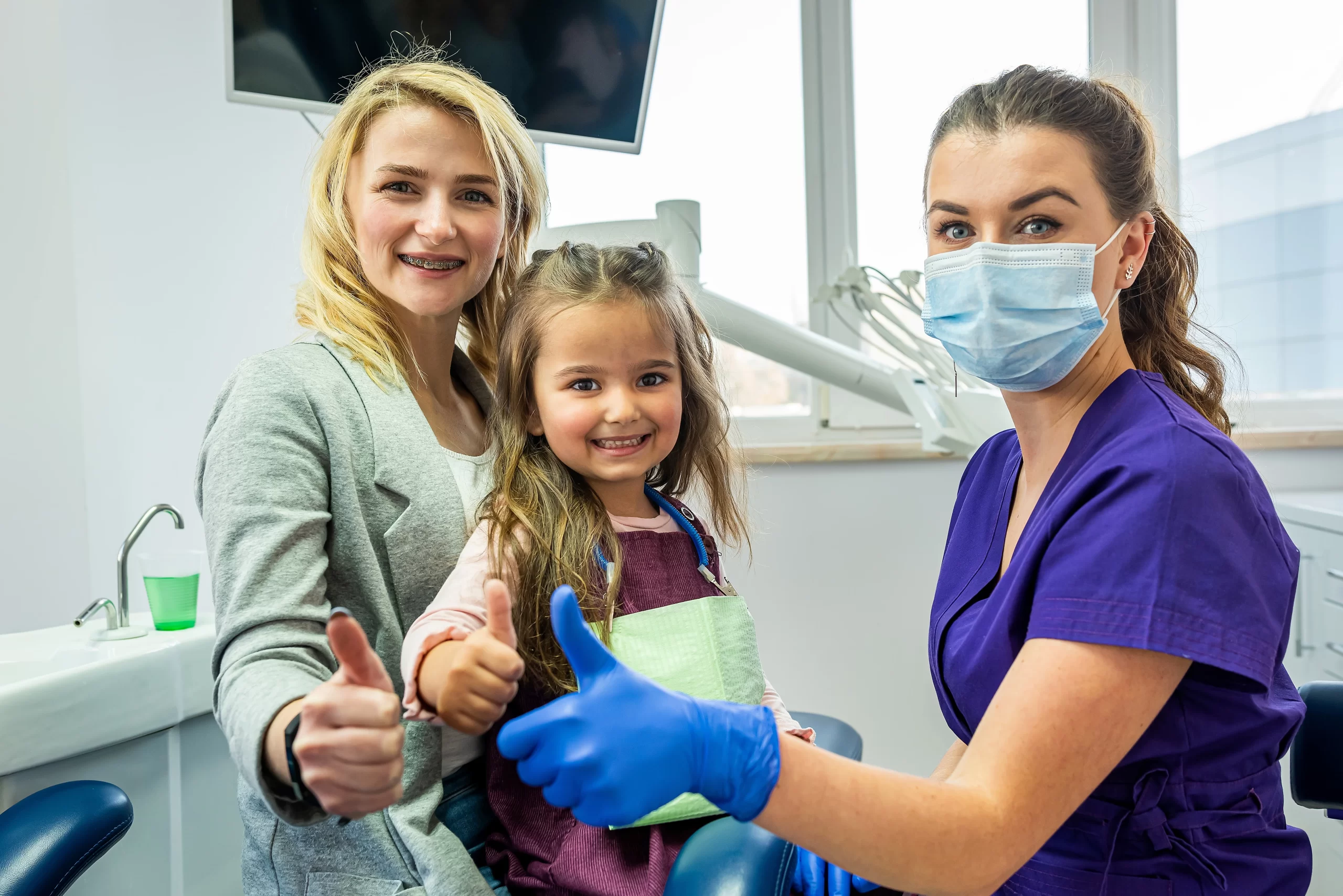 Dentist with child and parent giving thumbs up. Space Maintainers For Kids