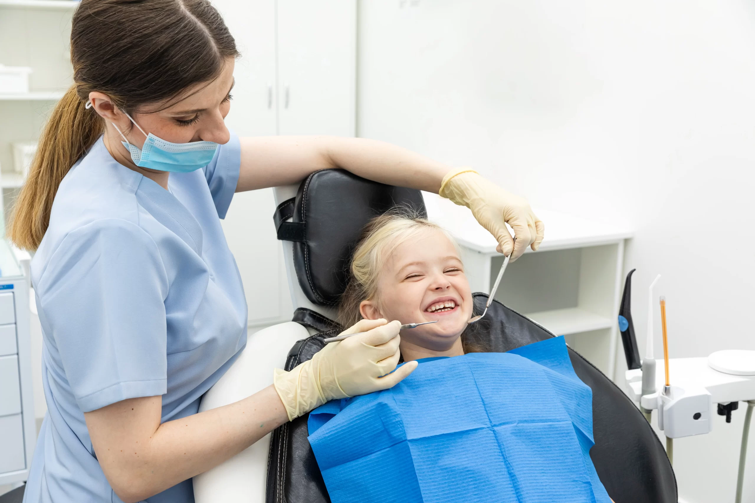 Smiling child during dental checkup with dentist.