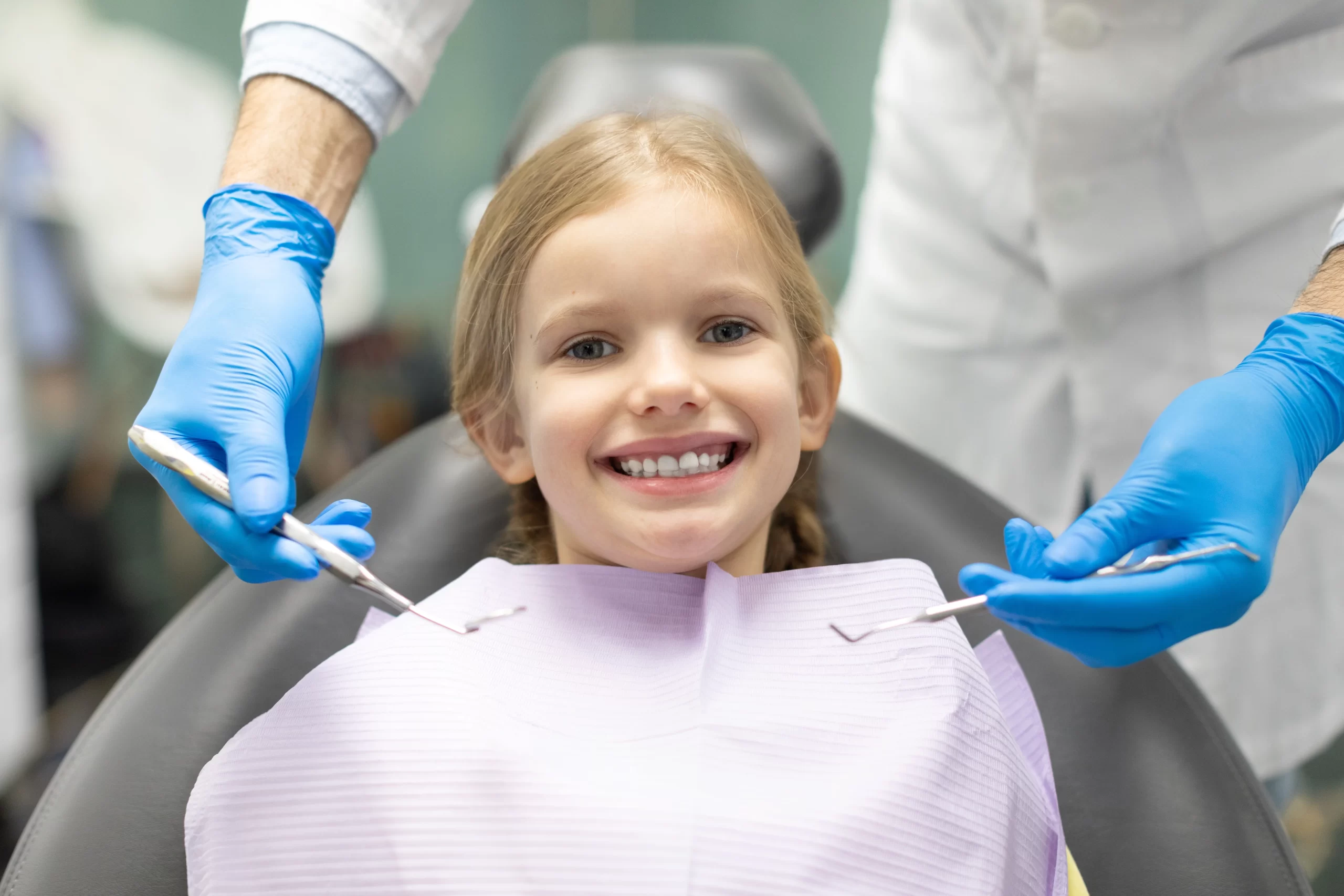 Smiling child at dentist with dental tools. Teeth Extractions For Kids