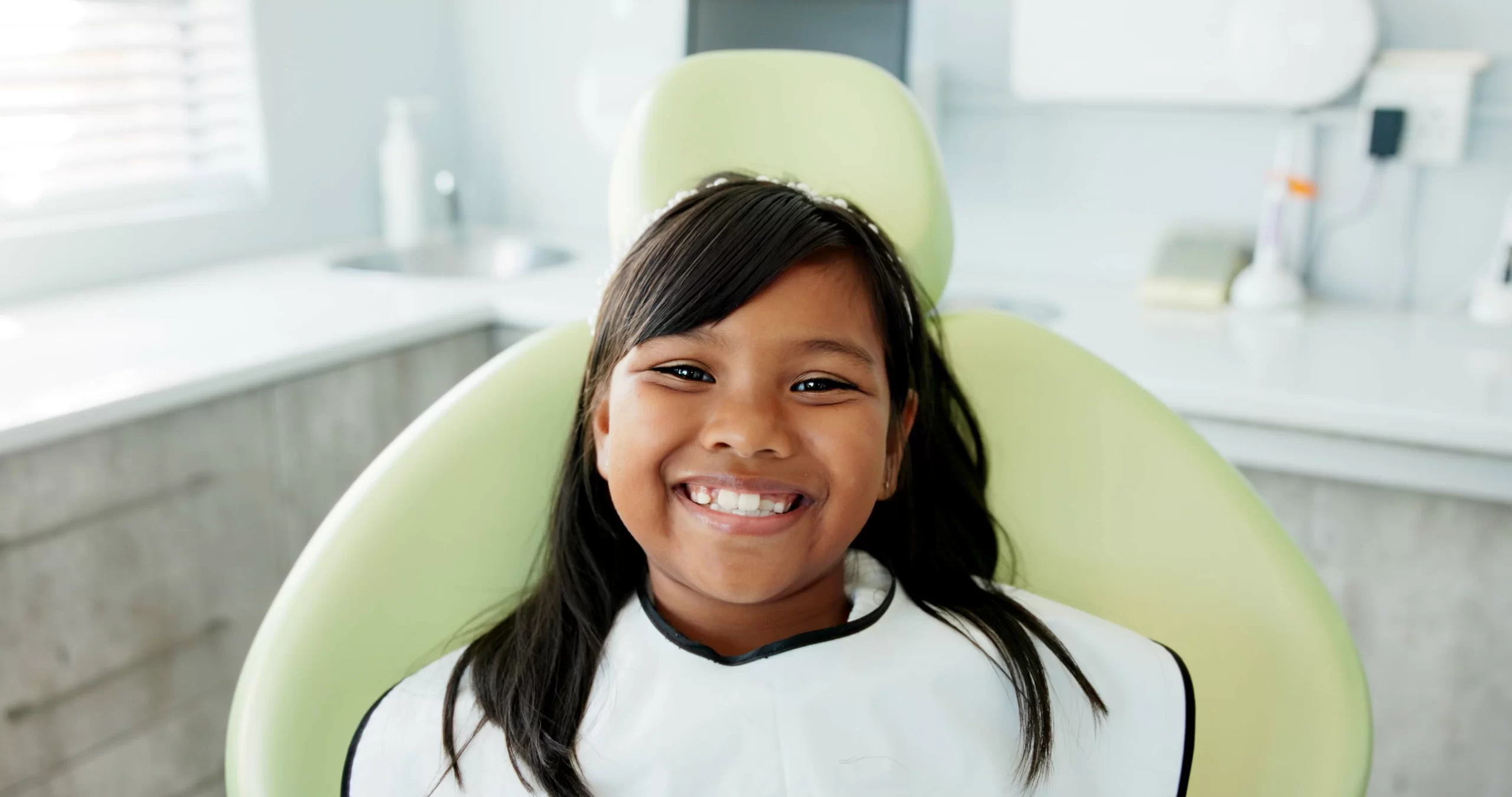 Child smiling in dental exam chair