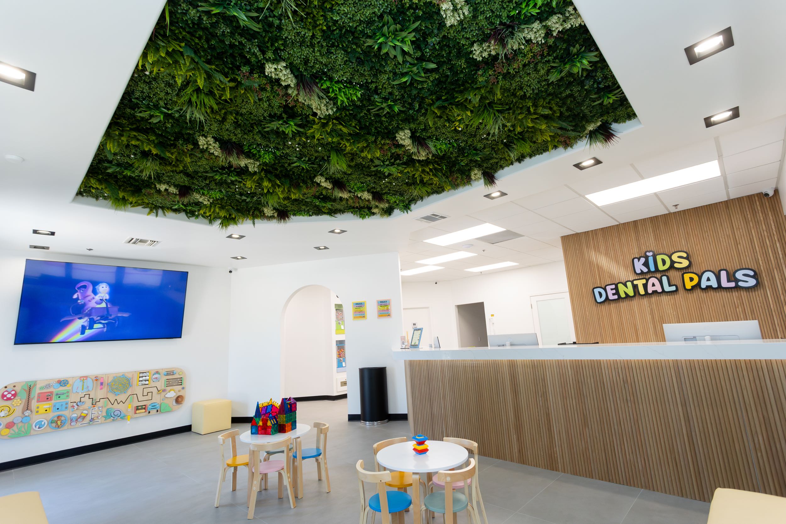 Kids dental office with play area and greenery ceiling.