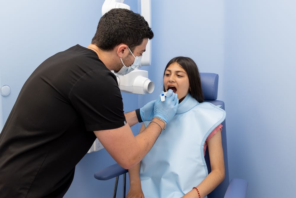 Dentist examines patient's mouth in dental office.