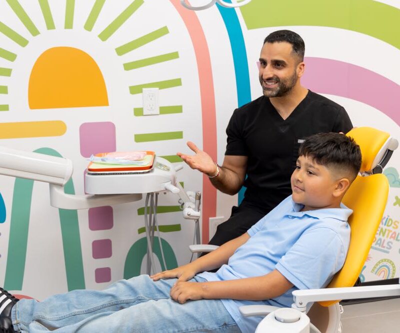 Dentist with kid in colorful dental office.