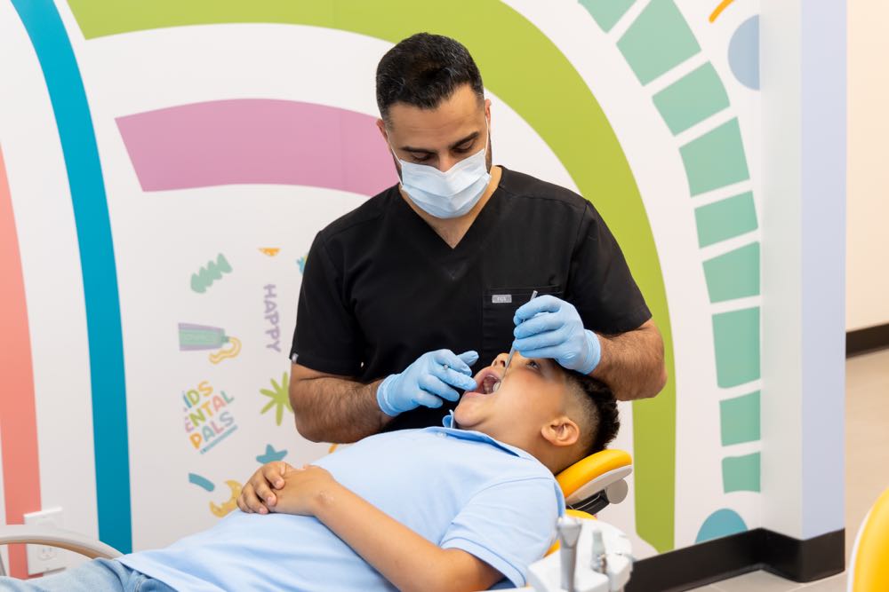 Dentist examines child's teeth in colorful clinic